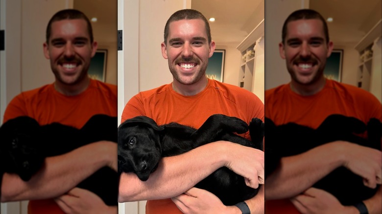Christopher Schwarzenegger holding a dog and smiling