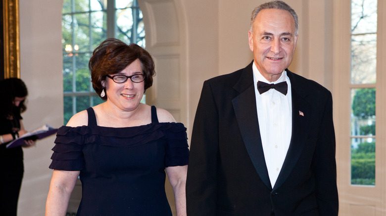 Chuck Schumer and Iris Weinshall walking side by side in their finery