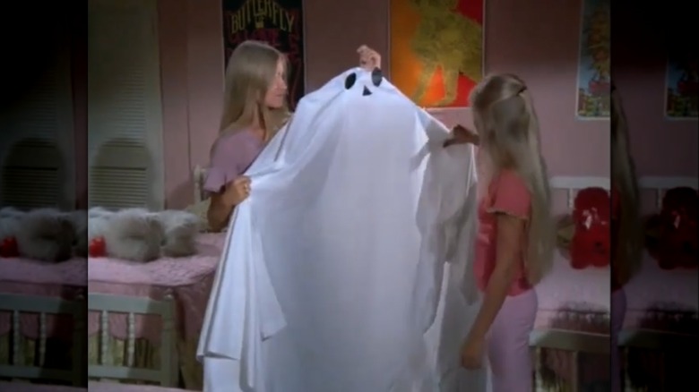Maureen McCormick and Eve Plumb holding a ghost decoration