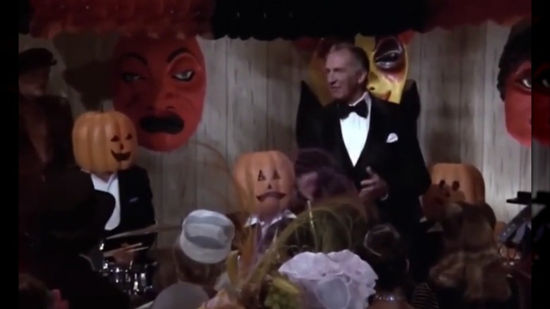 Vincent Price talking to a crowd of people in Halloween costumes