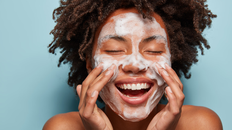 Woman washing face smiling