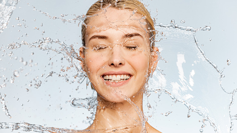 A woman splashing her face with water 