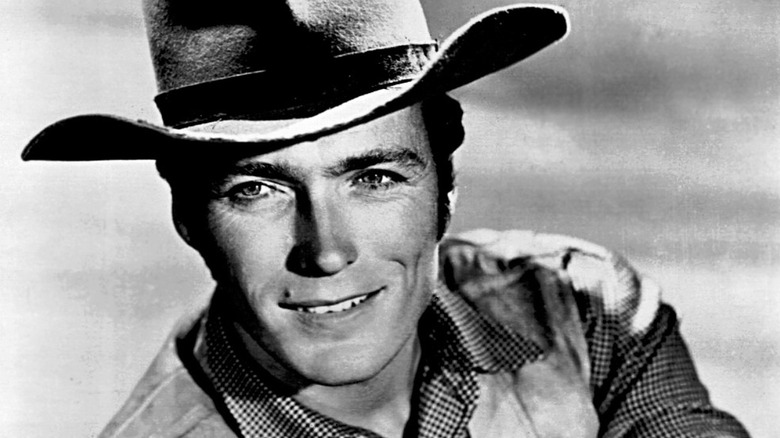 Black and white photo of Clint Eastwood wearing a cowboy hat and smiling in a publicity shot for Rawhide