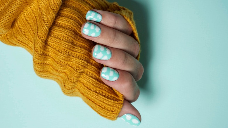 yellow sweater and cloud nails 