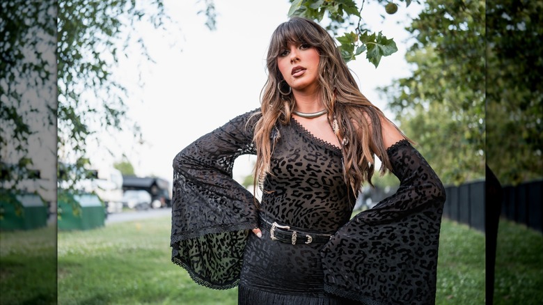 Ella Langley posing in black leopard-print outfit