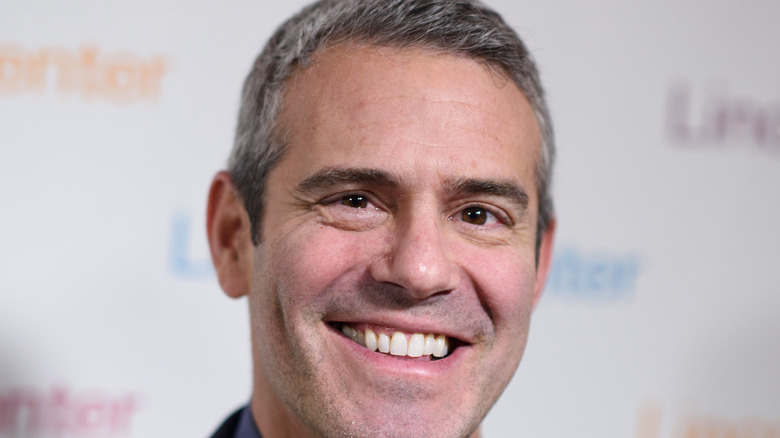 Andy Cohen smiles at an event