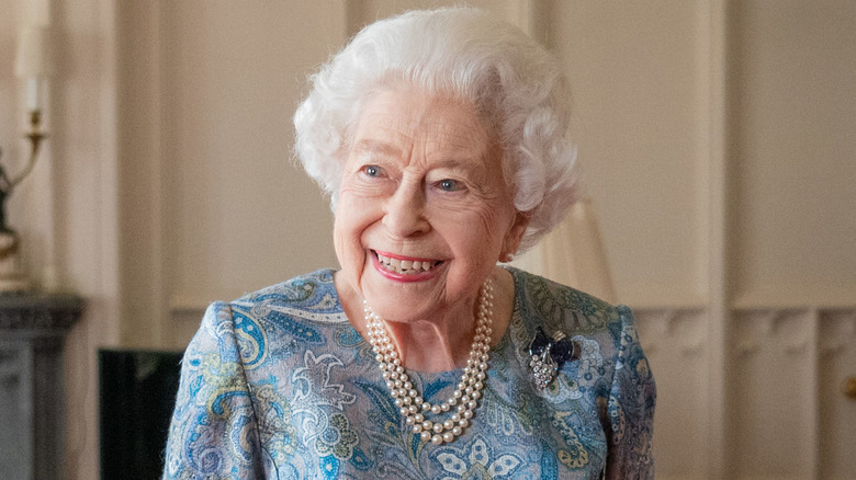Queen Elizabeth II smiling indoors in 2022