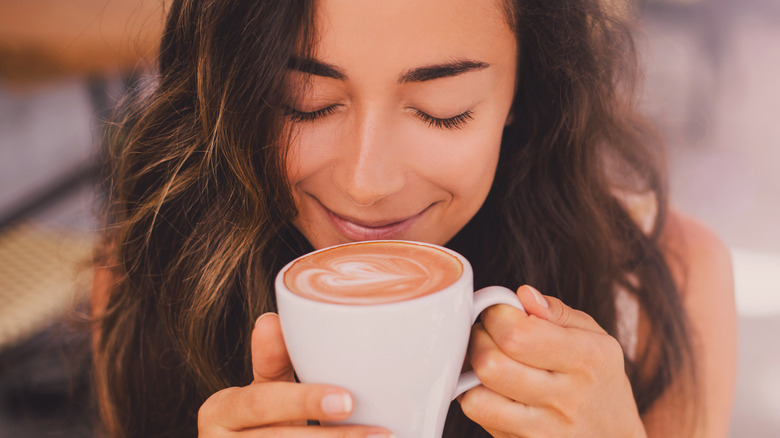 Woman smiling while sipping coffee