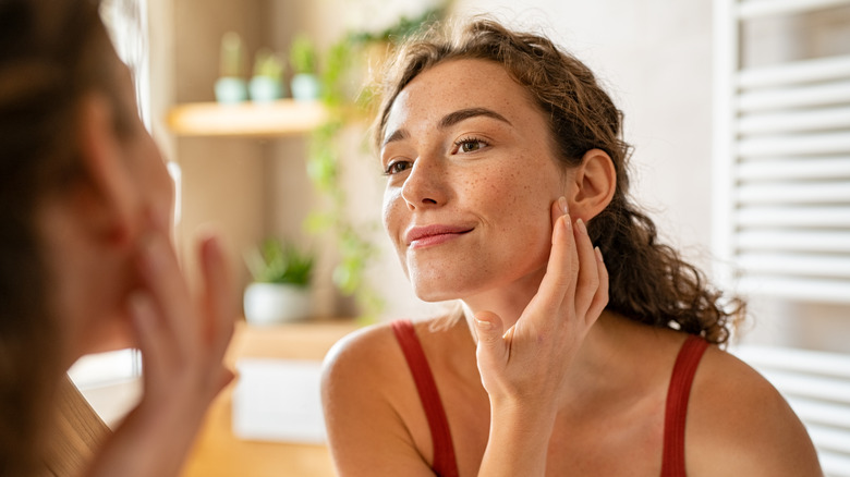 woman looking at pimple