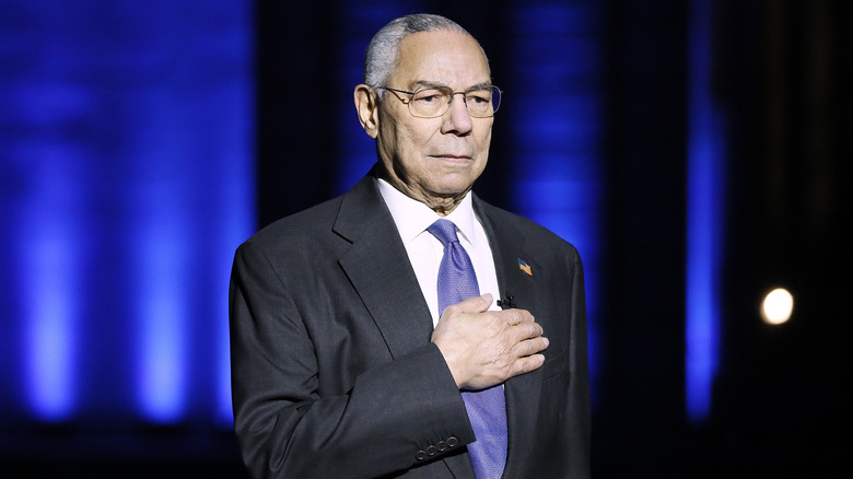 Colin Powell with hand over heart at an event 