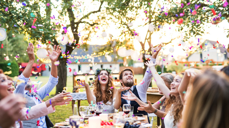 Bride and groom throwing confetti at table