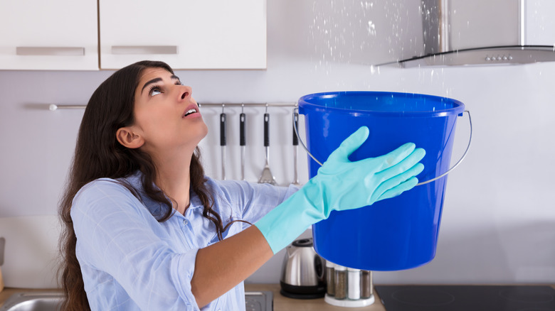 woman holding bucket to catch water