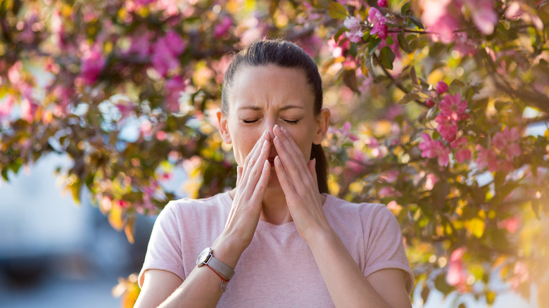 Woman sneezing because of an allergy 