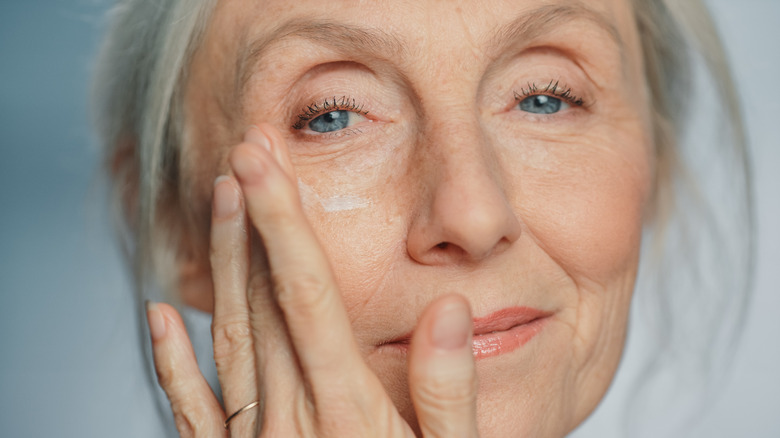 older woman touching face