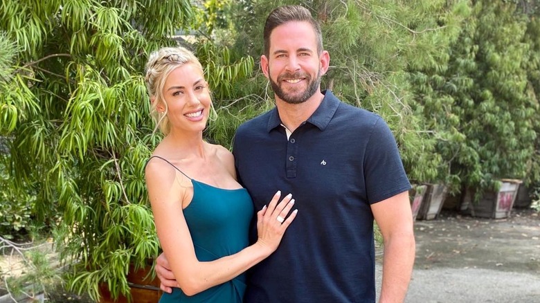 Tarek and Heather Rae El Moussa posing outside