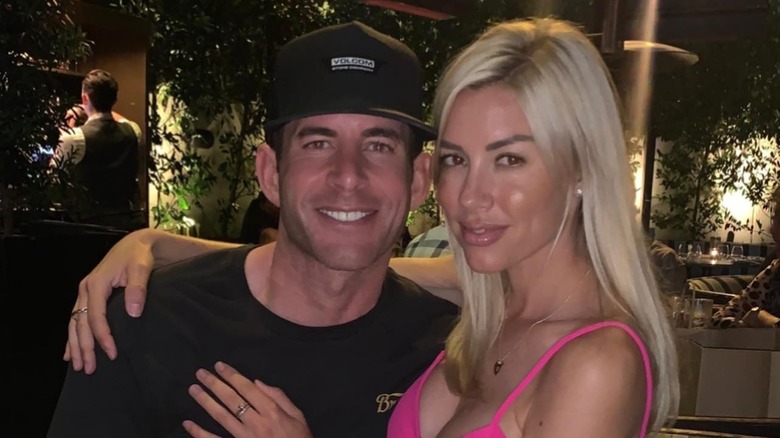 Tarek El Moussa and Heather Rae Young posing at restaurant