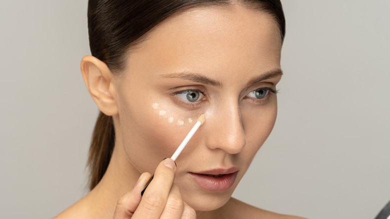 woman applying concealer 