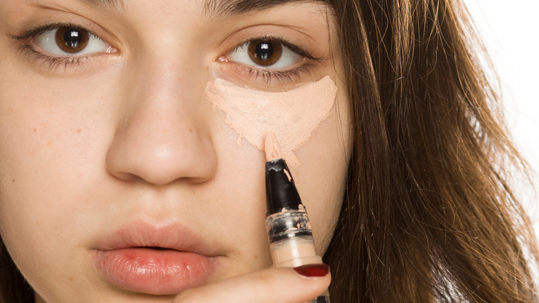 Woman applying concealer