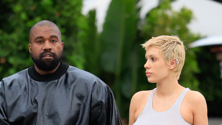 kanye west and bianca censori hold hands while waling
