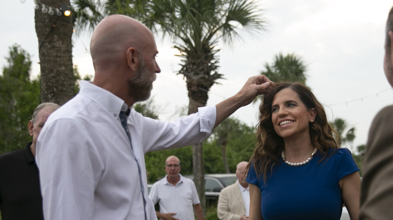 Patrick Bryant moving Nancy Mace's hair out of her face at an outdoor event