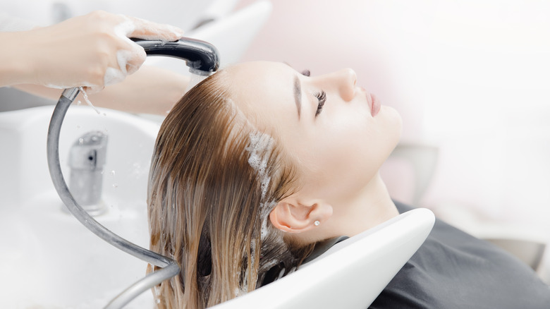 A woman getting her hair washed at a salon