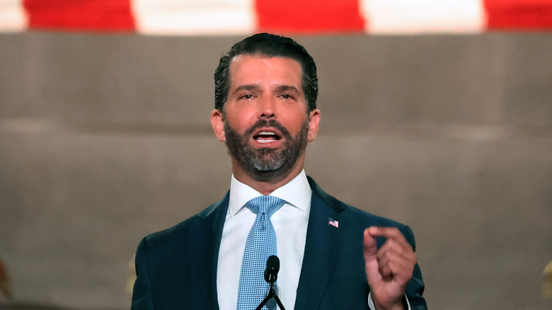 Donald Trump Jr. speaking under a giant American Flag at the Republican National Convention in 2020