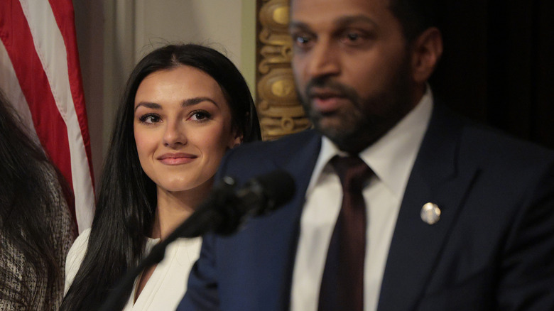 Alexis Wilkins watching Kash Patel give a speech.