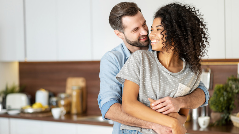 Man hugging woman in kitchen