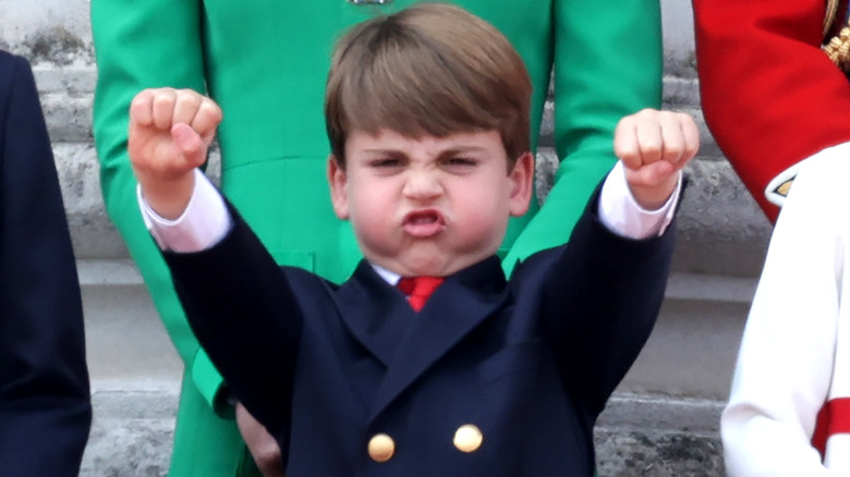 Prince Louis puffing his cheeks and fist pumping the air with both hands