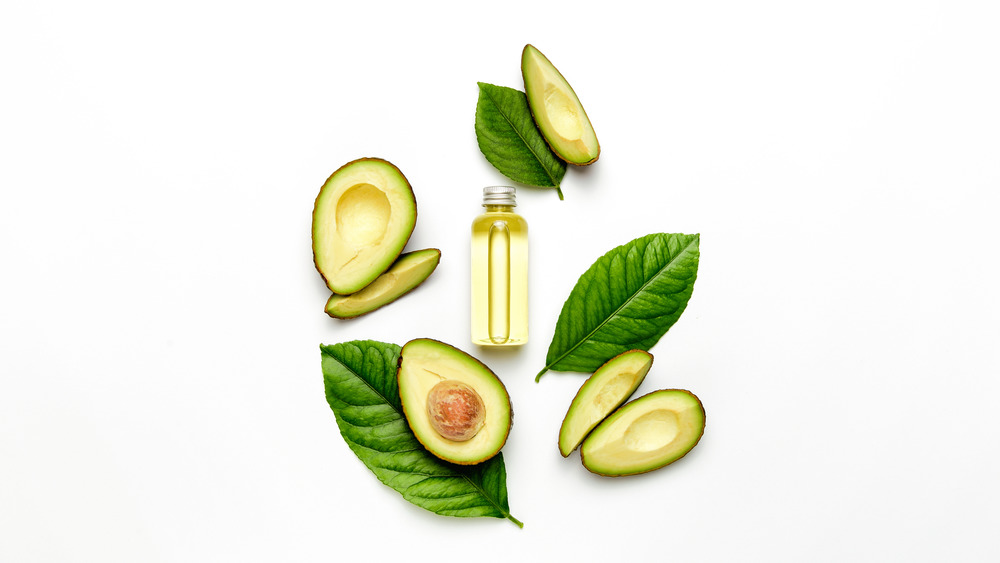 Avocado oil surrounded by avocados