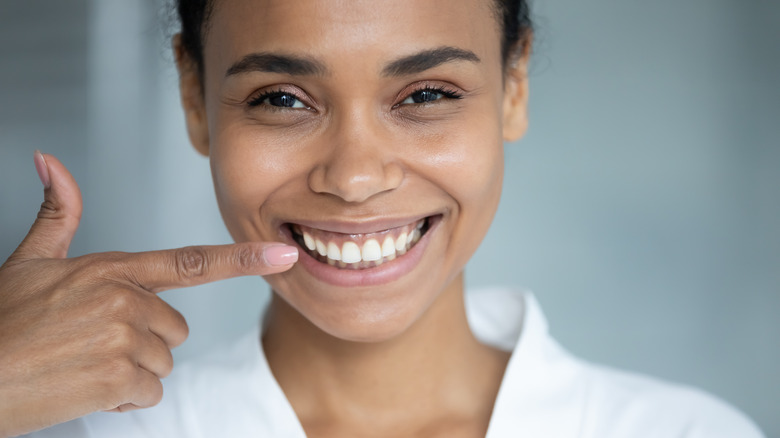 Smiling woman pointing to her teeth