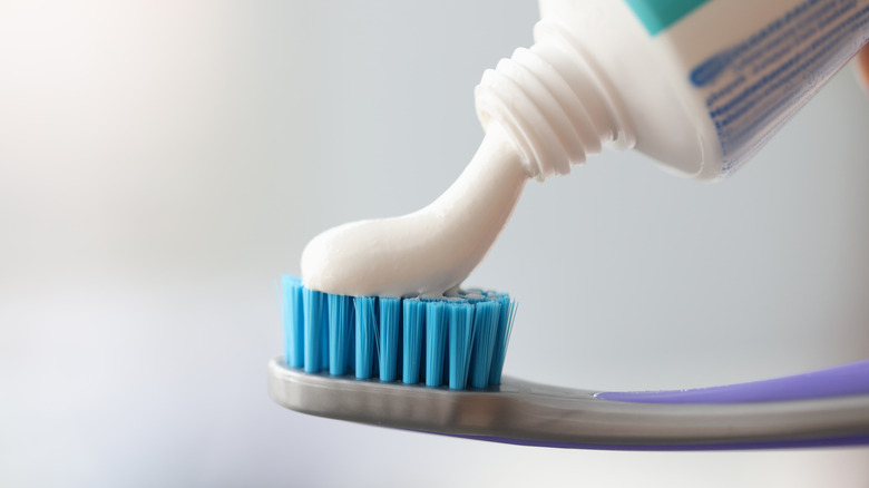 toothpaste being applied to toothbrush