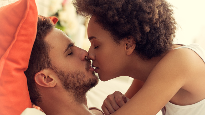 couple kissing in bed