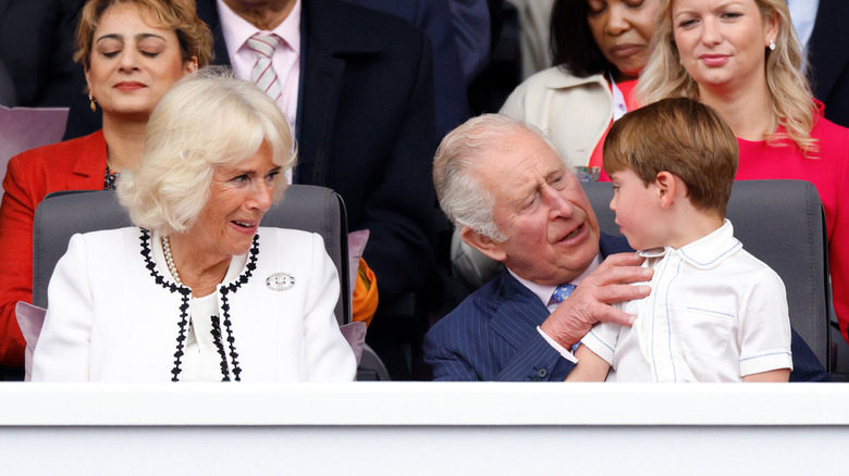 Queen Camilla and King Charles looking at Prince Louis sitting on his grandfather's lap in 2022