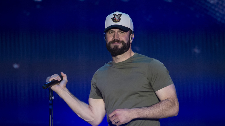 Sam Hunt holding a microphone on stage