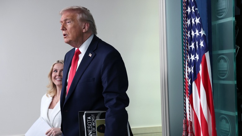 Karoline Leavitt looking up at Donald Trump, partially obscured from the camera