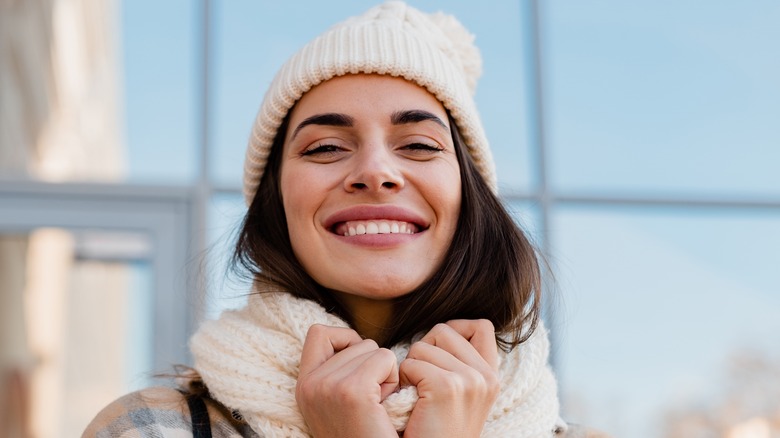 Woman in the cold wears a scarf and beanie