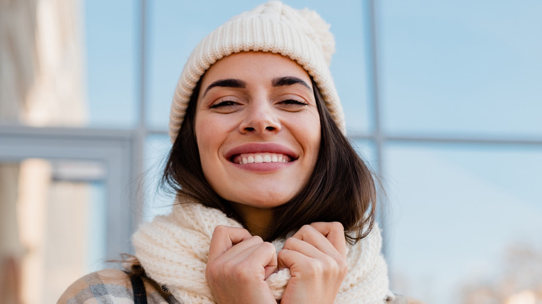 Woman in the cold wears a scarf and beanie