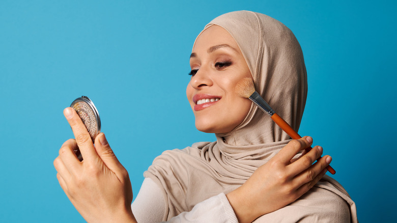 A woman applying bronzer 