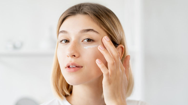 Woman using moisturizer