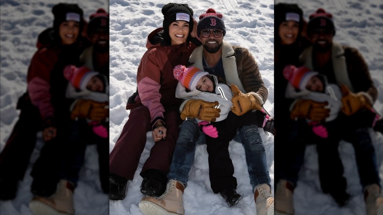 Jesiree Dizon and Shemar Moore cradle their daughter for a snowy photo