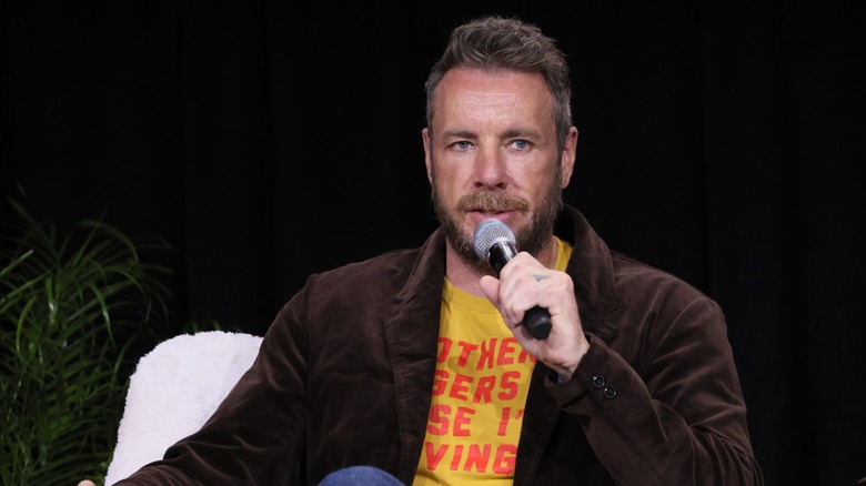 Dax Shepard holds a microphone for an interview