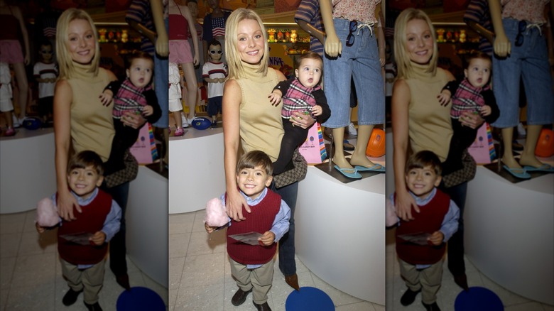 Kelly Ripa holds daughter Lola and smiles next to son Michael