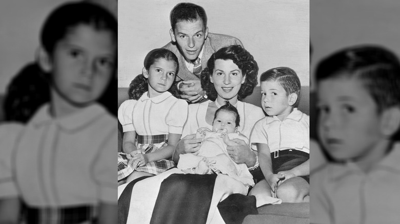 The Sinatra family, now including Tina Sinatra, sit around the couch.
