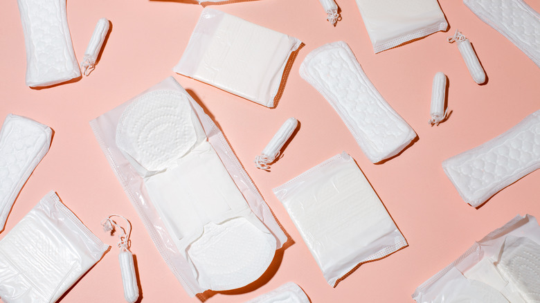 Tampons and menstrual pads on a pink background