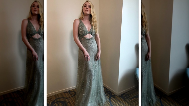 Dakota Fanning inside wearing a floor-length green gown with a lot of sparkles and a cut-out abdomen