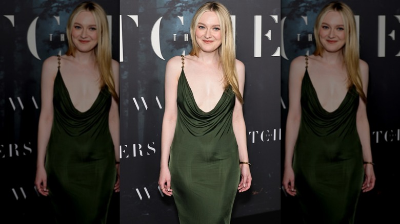 Dakota Fanning on the red carpet in an army-green dress with a cowl neckline that falls to mid torso