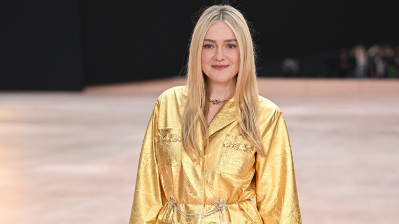 Dakota Fanning in a silky gold top with pockets and gold embellishments