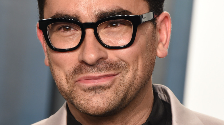 Dan Levy smirking an event