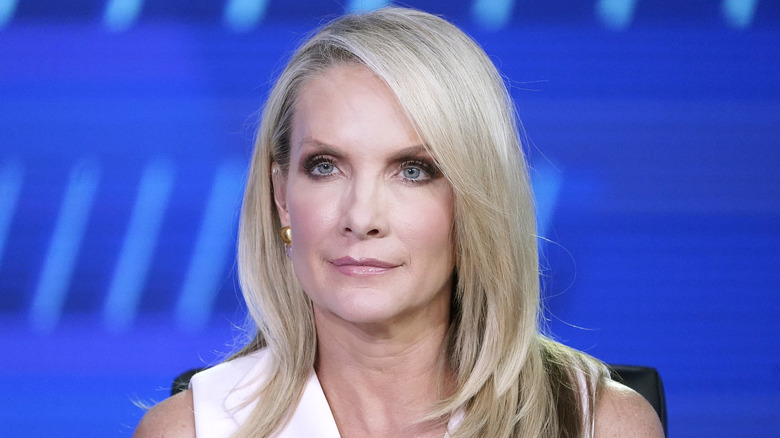 Dana Perino smirking in a white dress while sitting down on 'The Five.'